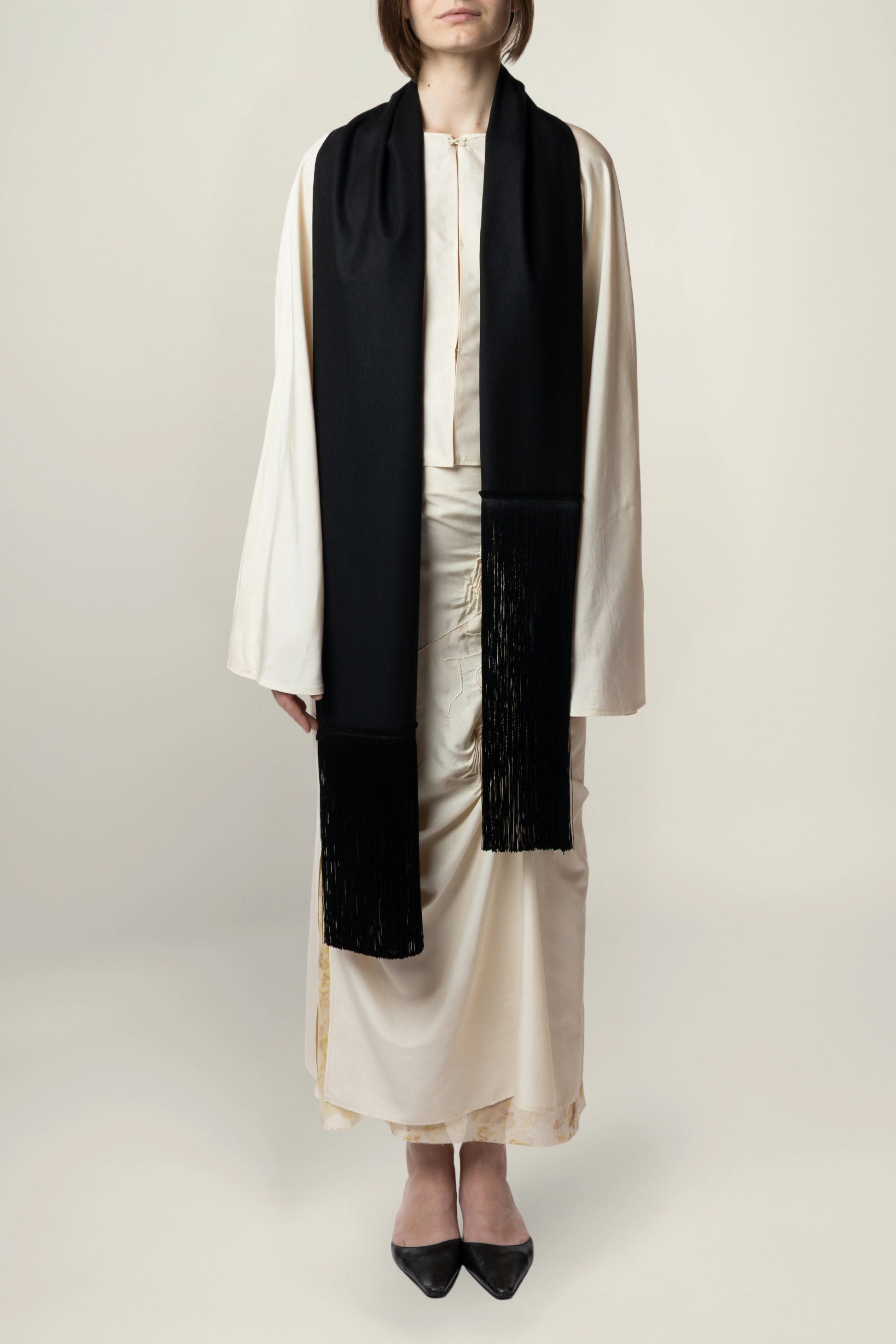 Brisa Scarf - Black | MAISON MAGDALENA | A long wool scarf with a handmade fringed finish | Model picture