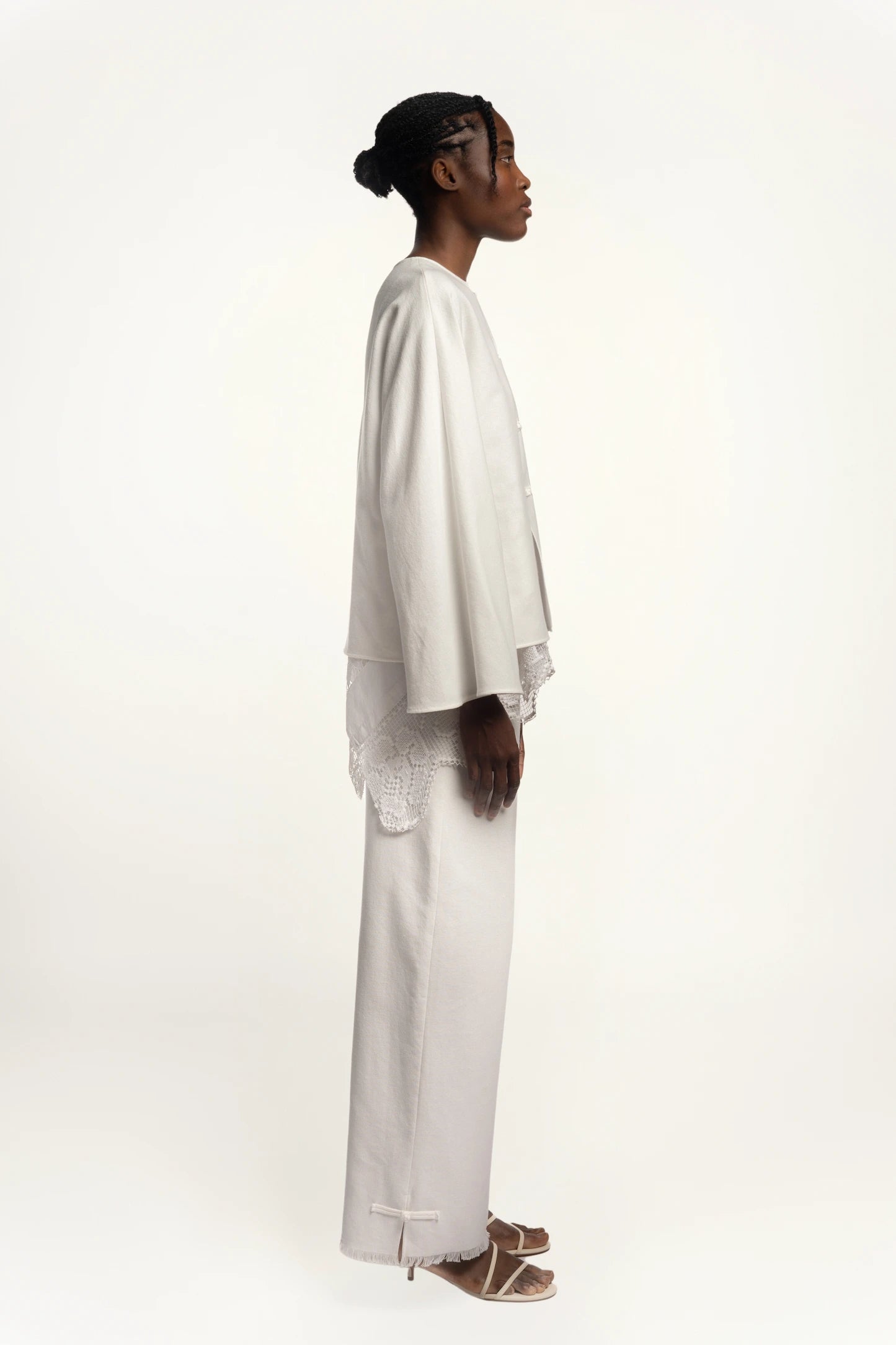 Cruise Trousers | MAISON MAGDALNEA | White cotton trousers with a handmade frog button as decoration at the bottom | Full model picture lateral view