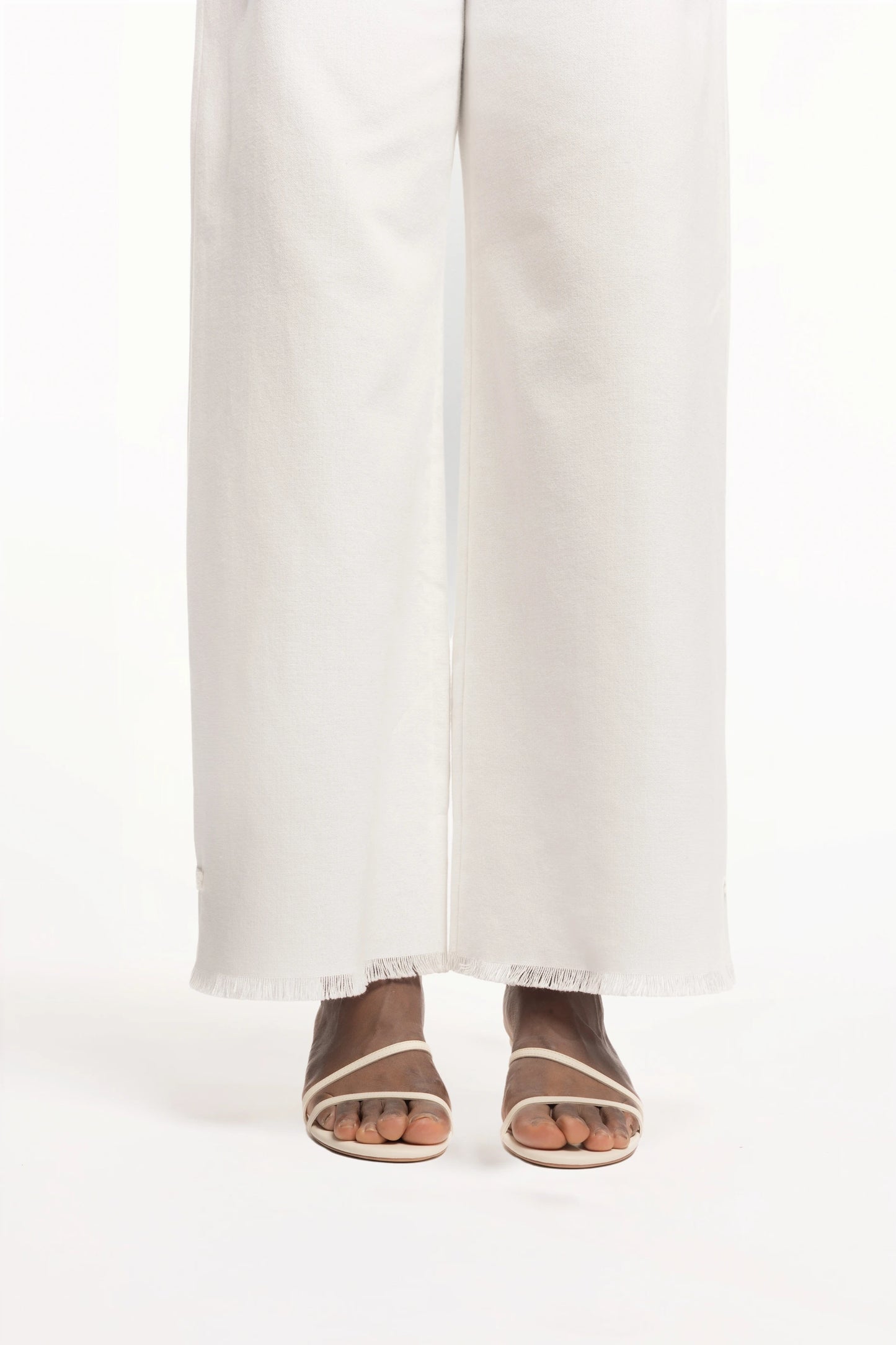 Cruise Trousers | MAISON MAGDALNEA | White cotton trousers with a handmade frog button as decoration at the bottom | Close up model picture front view