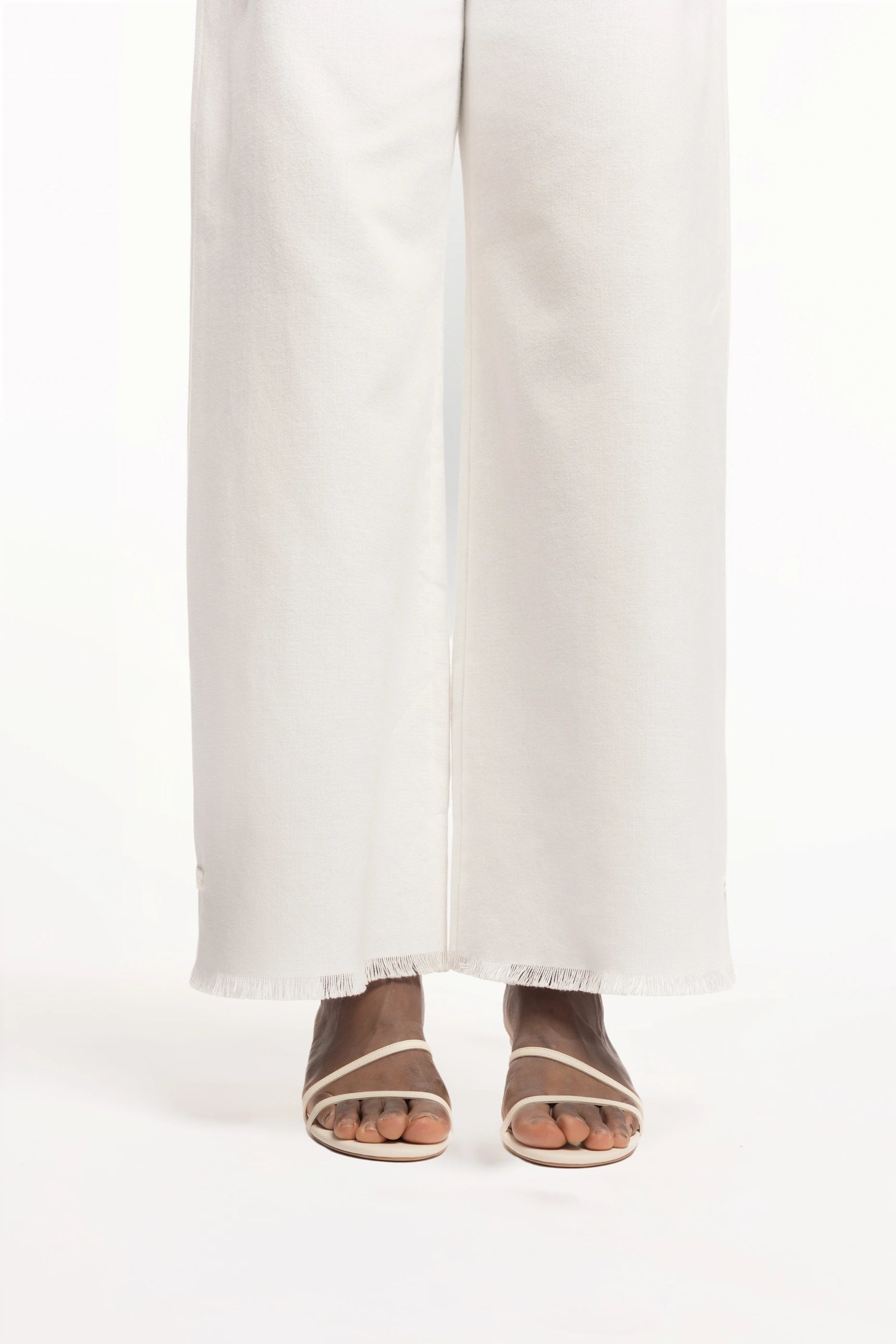 Cruise Trousers | MAISON MAGDALNEA | White cotton trousers with a handmade frog button as decoration at the bottom | Close up model picture front view